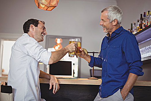 两个男人,祝酒,啤酒杯,餐馆