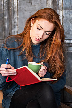 美女,长,红发,坐,桌子,拿着,笔记本,咖啡杯