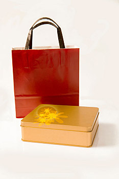 金色礼盒与红色手提袋在白色背景
