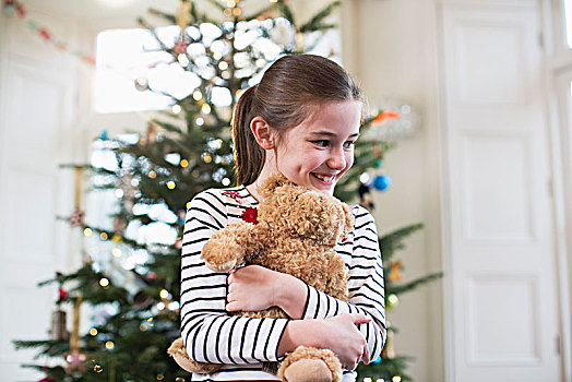 高兴,女孩,搂抱,泰迪熊,正面,圣诞树