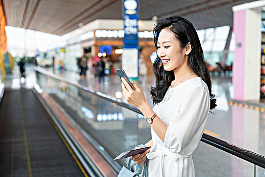年轻女子在机场使用手机