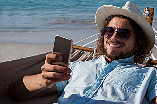 男人,放松,吊床,打手机,海滩,微笑