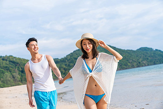 快乐的年轻情侣在海边散步