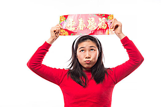 快乐年轻的亚洲女子拿着,空白的红对联为庆祝中国农历新年
