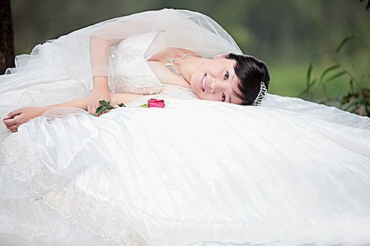 穿婚纱的女子优美的躺在婚纱上