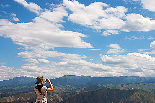 户外摄影站在山顶的女青年