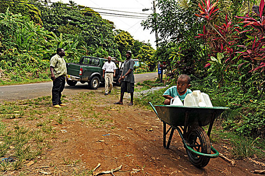 dominica,carib,territory,little,boy,playing,in,wheelbarrow