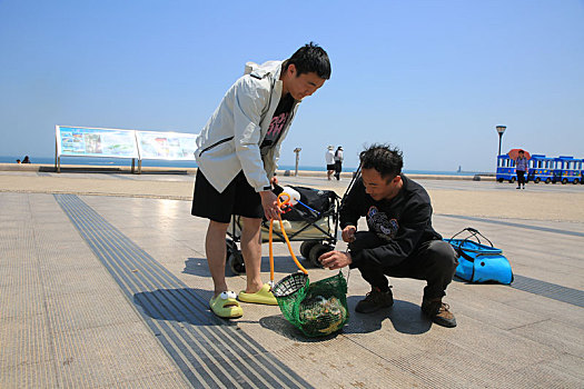 山东省日照市,90后小伙潜水捞海鲜上岸,游客蜂拥而至看稀罕