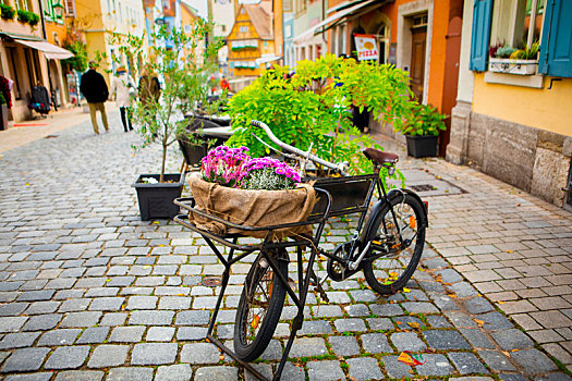 德国罗腾堡童话镇古老的街道上商家在脚踏车布置的花篮