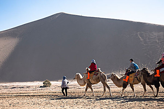敦煌鸣沙山沙漠公园骑骆驼的游客队伍