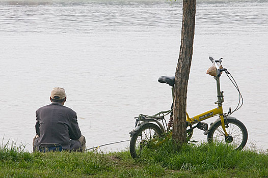 河南洛阳河边钓鱼的老人和他的自行车