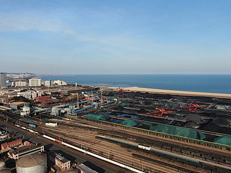 山东省日照市,航拍蓝天白云下的港口煤炭堆场,座座煤山一眼望不到边