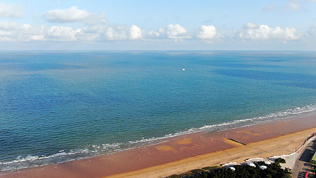 山东省日照市,秋日里的海水浴场碧波万顷,游客漫步海滩享受悠闲周末