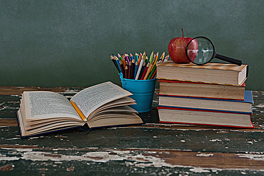 一堆,书本,苹果,放大镜,笔,固定器具,木桌子