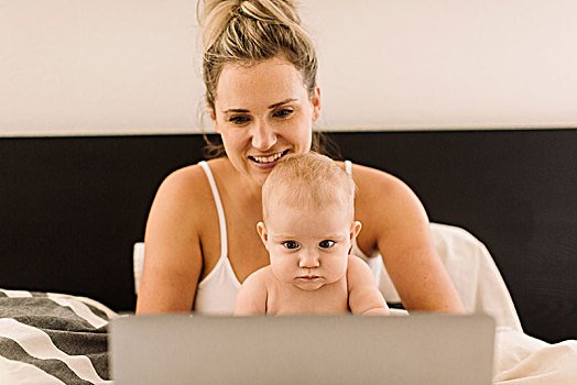女婴,母亲,坐,向上,床上,凝视,笔记本电脑