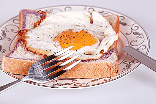 特写用刀叉吃煎鸡蛋配面包