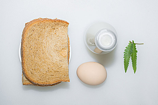 面包鸡蛋配牛奶的营养早餐,一片绿叶点缀