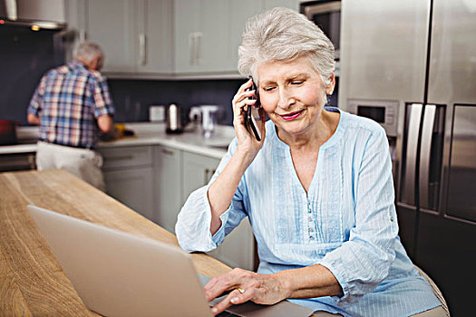 老年,女人,交谈,打电话,使用笔记本,男人,工作,厨房,在家