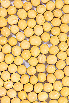 木勺子舀黄豆在铺满黄豆的背景上