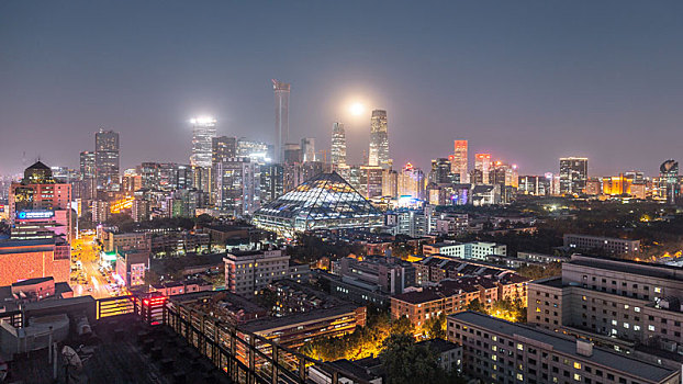 夜幕降临,一轮明月从北京城上空升起