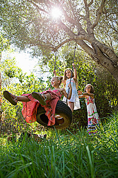 仰视,三个女孩,玩,树上,轮胎秋千,花园