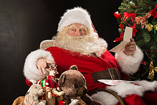 圣诞老人,坐,在家,舒适,扶手椅,拿着,信封,读,信,愿望,选择,玩具,大,袋,靠近