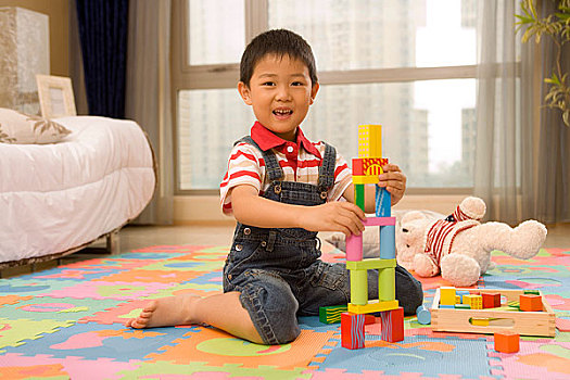 一个小男孩在地板上塔积木