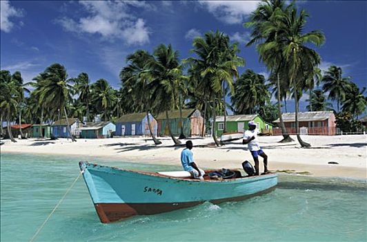 西印度群岛,多米尼加共和国,绍纳岛,两个男人,船,蓝绿色海水,海滩,棕榈树,彩色,房子,背景