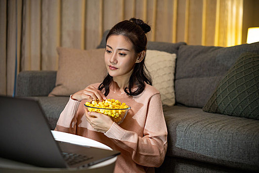 年轻女士在家吃使用电脑