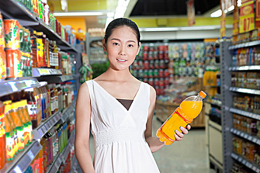 一个青年女人在超市购买饮料