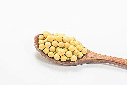 木勺子舀黄豆在白色背景上