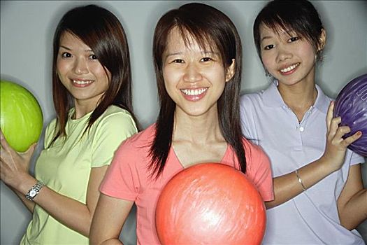 三个女人,年轻,拿着,保龄球,看镜头,微笑