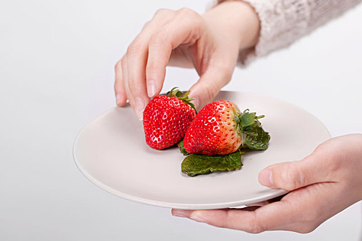 手拿盘子里的草莓