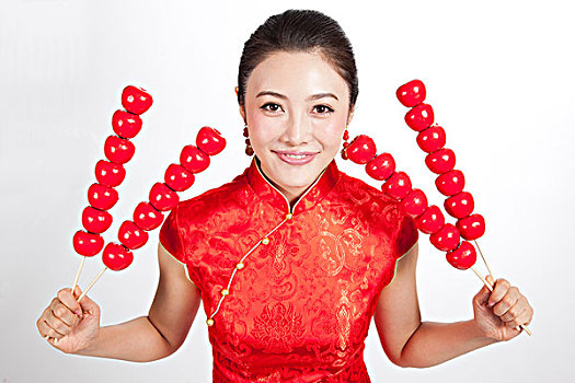 棚拍身穿中国传统服装的年轻女人和糖葫芦