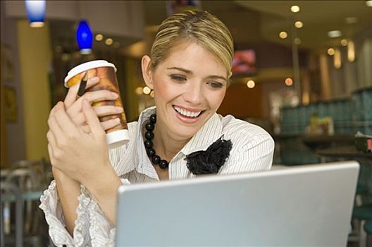 职业女性,看,笔记本电脑,拿着,一次性杯子,餐馆