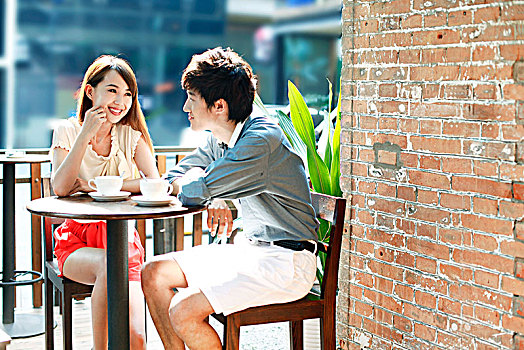 年轻情侣在户外咖啡厅约会