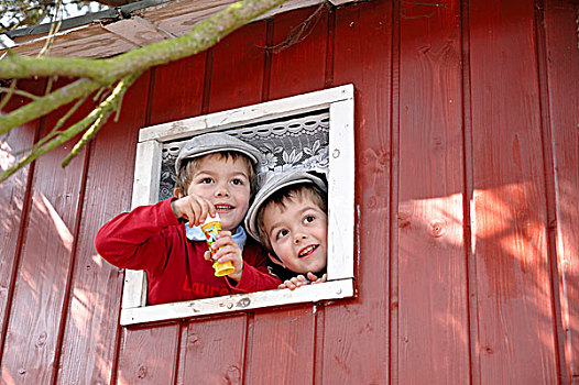 双胞胎,男孩,戴着,平顶帽,吹,肥皂泡,窗户,房子