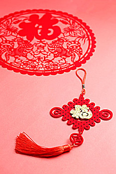 中国结和鸡年剪纸放在红色背景上