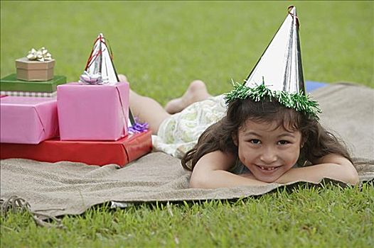 女孩,躺着,野餐毯,戴着,派对帽,看镜头,微笑