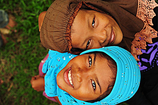 indonesia,sumatra,banda,aceh,two,smiling,girl,looking,up,with,colorful,veil