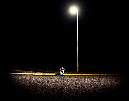 男孩,坐,人行道,夜晚,路灯