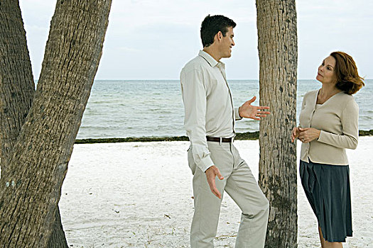 男人,女人,站立,靠近,树干,海滩,微笑,相互