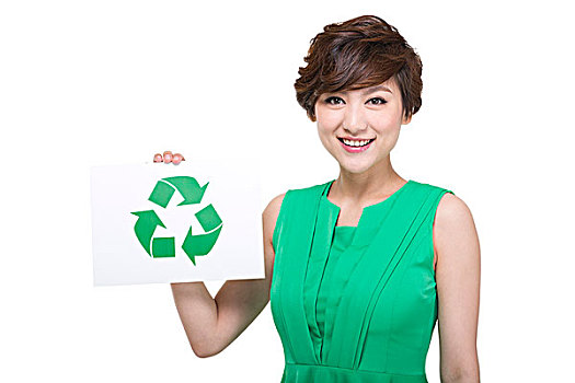 穿绿色裙子的年轻女人拿着环保标志
