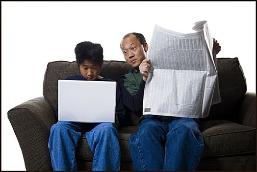 特写,父亲,拿着,报纸,儿子,笔记本电脑