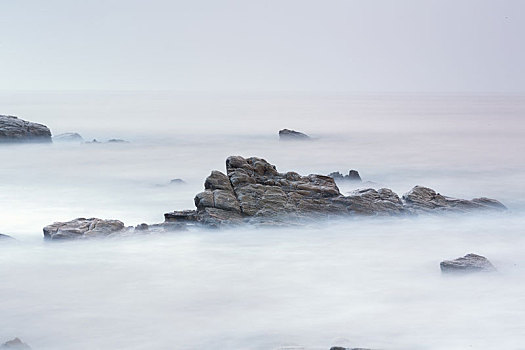 中国山东省日照市任家台海滨礁石公园早晨飘渺的海面风光