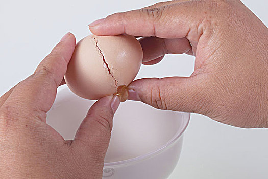 两只手将打开的鸡蛋放在碗里