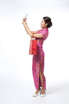 棚拍身穿中国传统服装的年轻女人购物打电话