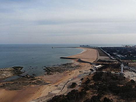 山东省日照市,立春后的日照海边天高云淡,市民赶海拾贝漫步沙滩感受假日美好时光