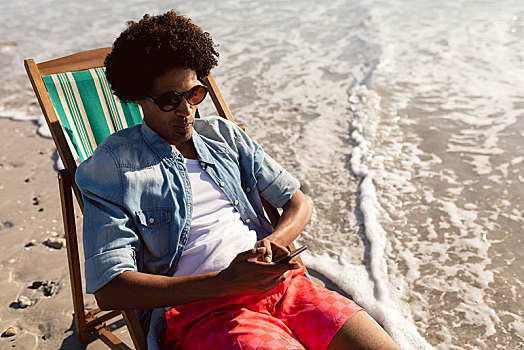 男人,打手机,放松,沙滩椅,海滩
