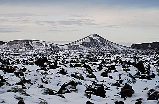 iceland,blue,lagoon,view,of,rocky,lava,field,with,snowcapped,hills